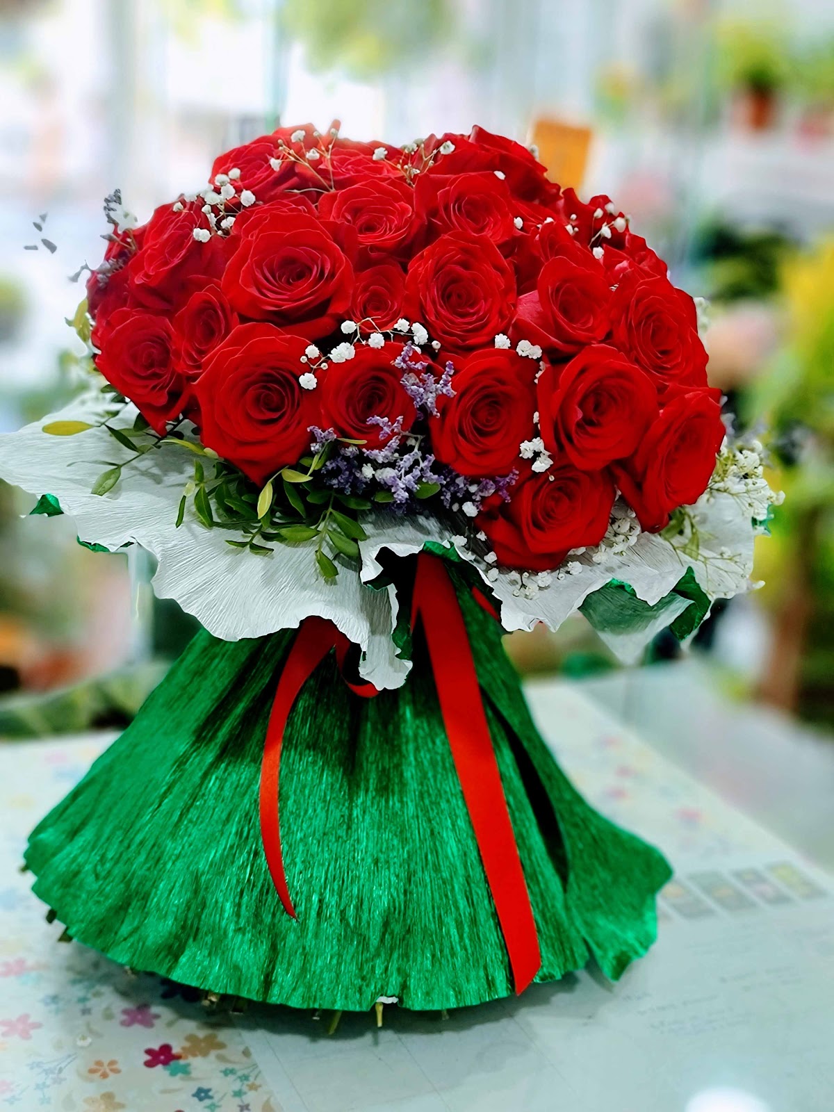 Gran ramo de rosas rojas con paniculata y envoltorio verde